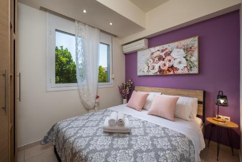 a bedroom with purple walls and a bed with pink pillows at Levanta Cozy Apartment #1 in Kalavarda Rhodes in Kalavárda