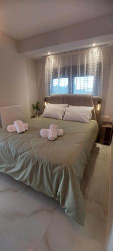 a large bed with two towels on top of it at Matin's cozy nest in Tríkala