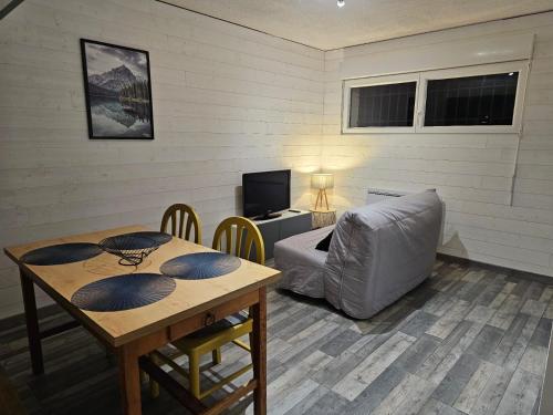 a living room with a table and a couch at Cozy 1-room apartment with veranda and parking in Font-Romeu