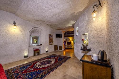 a hallway with a living room with a rug and a fireplace at Cappadocia Inn Cave Hotel in Goreme