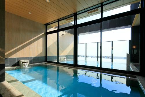 a swimming pool with a view of the ocean at Candeo Hotels Hiroshima Hatchobori in Hiroshima