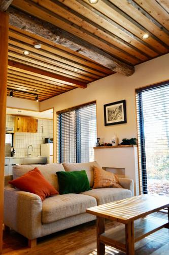 a living room with a couch and a table at The Misorano Cottage in Hakuba