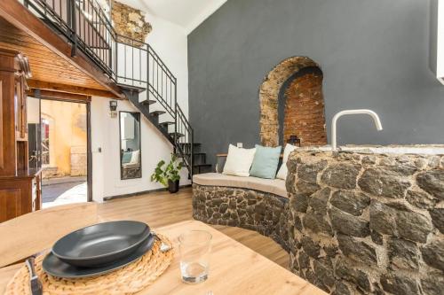 a living room with a stone wall and a table at Gesuiti Home - Lumina Collection in Catania