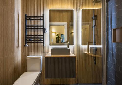 a bathroom with a sink and a toilet and a mirror at ºIM La Latina-City Centre-WiFi-AC-SmartTVº in Madrid