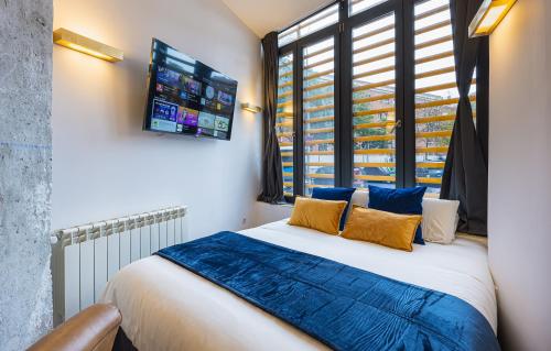 a bedroom with a bed with blue sheets and a window at ºIM La Latina-City Centre-WiFi-AC-SmartTVº in Madrid