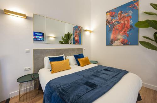 Un dormitorio con una cama grande con almohadas azules y amarillas. en A IM La Latina-City Centre-WiFi-AC-SmartTV A, en Madrid