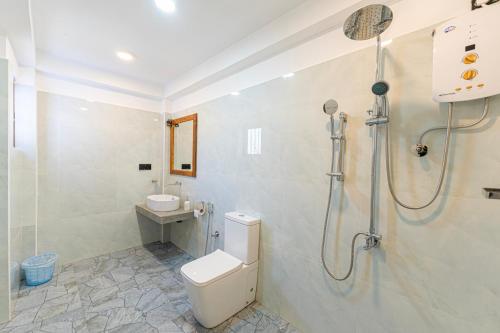 a bathroom with a shower and a toilet and a sink at Breeze Bay Villa in Dickwella