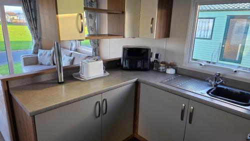 een keuken met een spoelbak en een aanrechtblad bij Cranfield Bay Getaway in Kilkeel