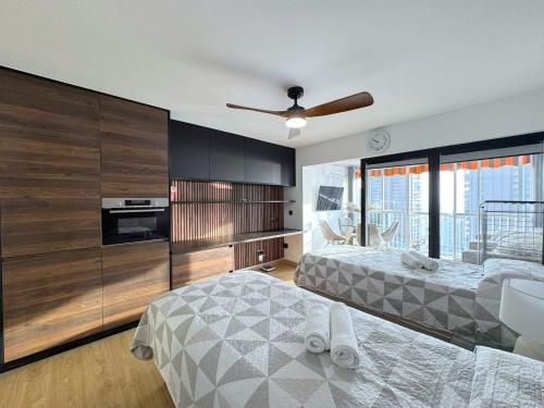 a bedroom with two beds and a ceiling fan at Albatros 13º in Benidorm