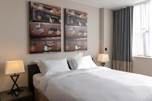a bedroom with a bed and two paintings on the wall at Hotel Xanadu in London