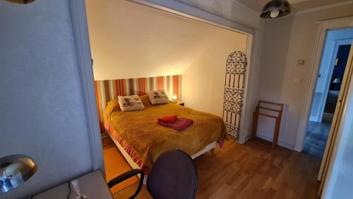 a bedroom with a bed and a chair in it at DOMAINE DES GRAVIERS in Plainfaing