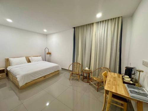 a bedroom with a bed and a table and chairs at Reatrey Inn in Phnom Penh