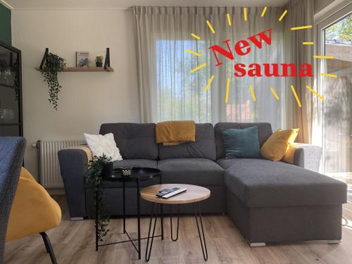 a living room with a couch and a new samurai sign at Chalet Aan de rand - Veluwe - met sauna in Putten