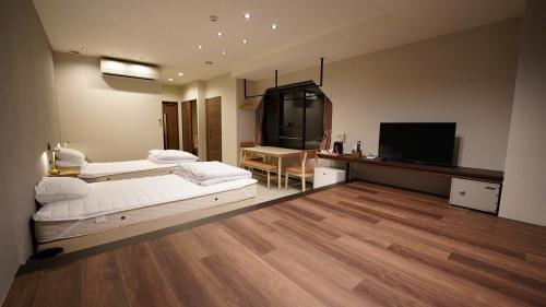 um quarto com duas camas e uma TV de tela plana em Hotel K Yuzawa 越後湯澤溫泉旅館 em Yuzawa