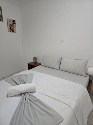 La Villa Moris, meublée et bien située في ليبرفيل: سرير أبيض مع أغطية ووسائد بيضاء