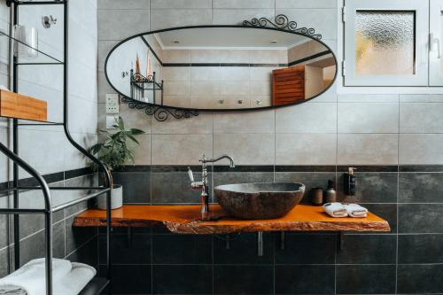 a bathroom with a sink and a large mirror at The Infinity 180 Luxury Suites in Milia