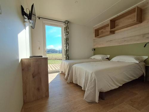 deux lits dans une chambre avec une fenêtre dans l'établissement Suite Hôtel, à Le Temple-sur-Lot