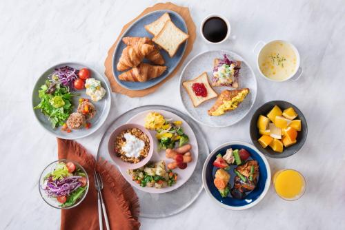 uma mesa coberta com pratos de comida e tigelas de comida em Candeo Hotels Hiroshima Hatchobori em Hiroshima