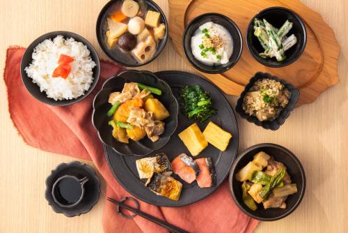 um grupo de pratos de alimentos sobre uma mesa em Candeo Hotels Hiroshima Hatchobori em Hiroshima