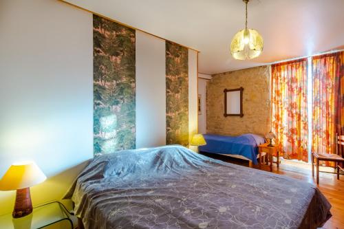 ein Schlafzimmer mit einem Bett in einem Zimmer mit Vorhängen in der Unterkunft Le Hibou - La Cipière Gîtes in Bardenac