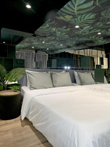a bedroom with a large white bed with a green ceiling at memore in Mons