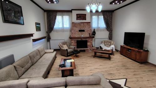 Una sala de estar con un sofá y un televisor. en Vila na Rtnju, en Rtanj