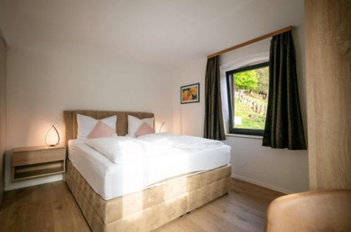 a bedroom with a large white bed and a window at Ferienwohnung Mimosa 302 in Wiggensbach