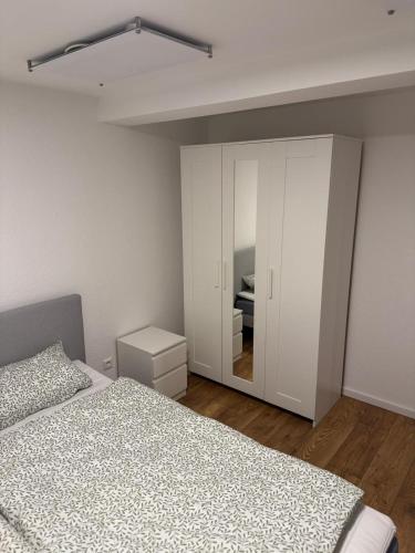 1 dormitorio con cama, armario y espejo en Große Wohneinheit Im Hotel weisses Lamm, en Bruchsal