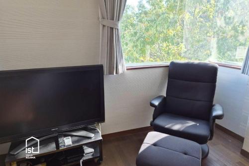 ein Wohnzimmer mit einem Stuhl und einem Flachbild-TV in der Unterkunft ist villa 06 Private Beachfront Sleeps 16 in Wada