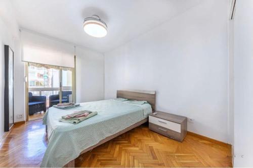 a bedroom with a bed and a wooden floor at Apartamento en 1ª línea de playa con parking privado in El Campello