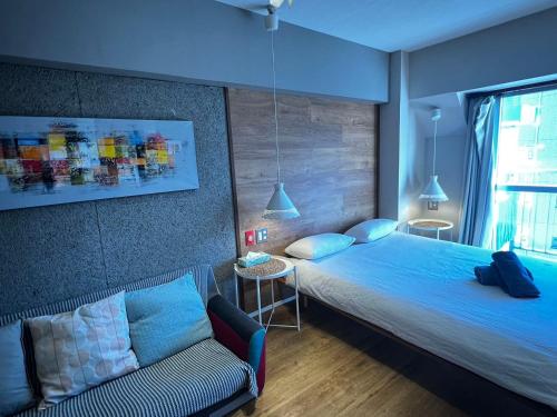 ein Hotelzimmer mit zwei Betten und einer Couch in der Unterkunft Shinjuku 1003 in Tokio