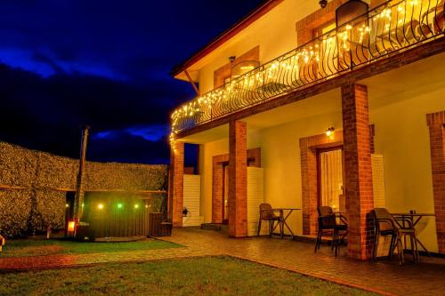 a house with a patio at night with lights at Edelweiss Vila Šventoji in Šventoji