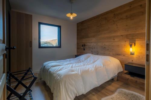 - une chambre avec un mur en bois et un lit dans l'établissement La Casses Bas, à Valloire