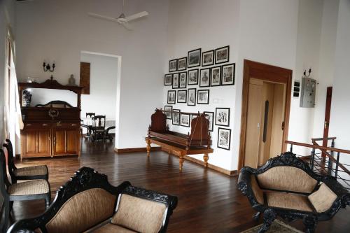 a living room with two chairs and a piano at Cirute' Talwatte, Kandy in Kandy