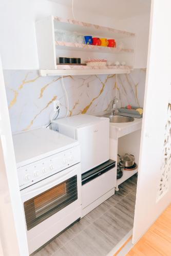 a kitchen with white appliances and marble walls at Apartman Lusi Vranje in Vranje