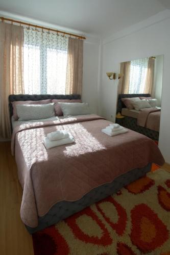 a bedroom with a large bed with two towels on it at Apartman Lusi Vranje in Vranje