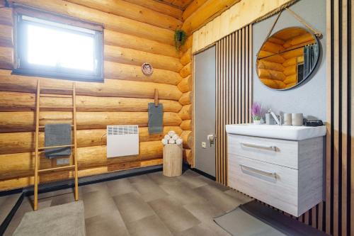 une salle de bain avec des murs en bois, un lavabo et une fenêtre dans l'établissement Zrub Polomka, à Brezno