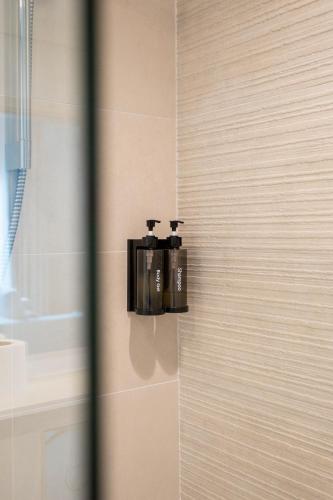 two soap dispensers on a wall in a bathroom at Elegant Studio apartment in Yas Golf collection with Balcony and Free parking l Near Yas water world & Ferrari World & Warner brothers in Abu Dhabi