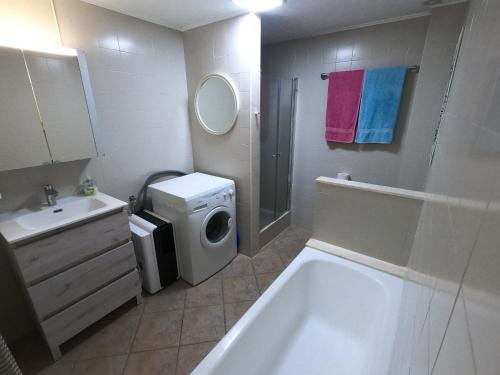 un bagno con lavandino e lavatrice di Gerry&Lotti Apartment a Son Bou