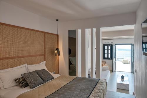 Un dormitorio con una cama grande con un cabecero grande. en Oia Suites, en Oia