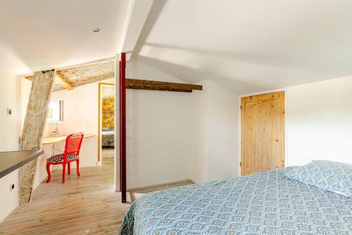 a bedroom with a bed and a desk and a chair at L'Atelier du Clos avec Jacuzzi in Puilboreau