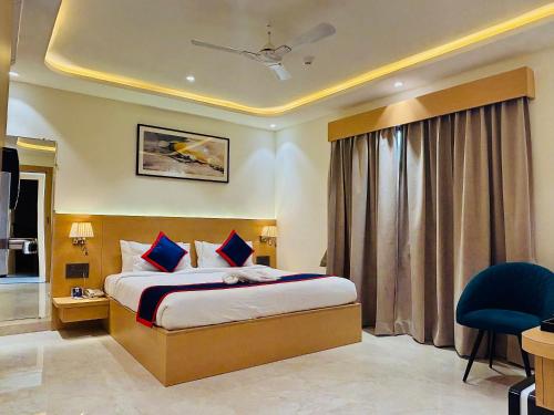 Una habitación de hotel con una cama y una silla azul. en Zip By Spree Hotels R Group, en Kota