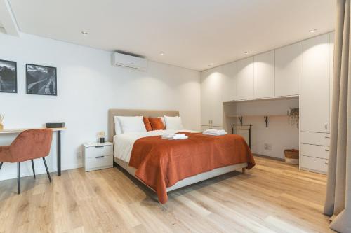 ein Schlafzimmer mit einem Bett, einem Schreibtisch und einem Tisch in der Unterkunft Breeze House 2 by Atlantic Holiday in Garajau