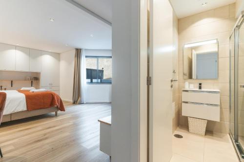 ein Schlafzimmer mit einem Bett und ein Badezimmer mit Dusche in der Unterkunft Breeze House 2 by Atlantic Holiday in Garajau