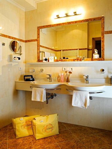 a bathroom with two sinks and a large mirror at Apart Hotel Garni Strasser in Zell am Ziller