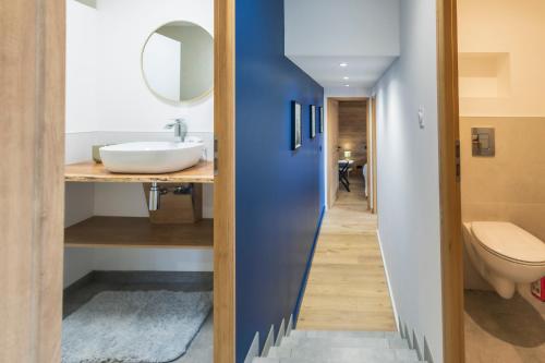 un couloir menant à une salle de bains avec lavabo et toilettes dans l'établissement La Casses Bas, à Valloire