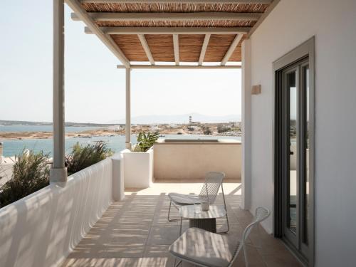 a patio with two chairs and a table on a balcony at Akria Seaside Suites in Naousa