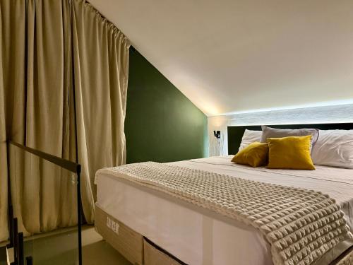 ein Schlafzimmer mit einem großen Bett mit einer grünen Wand in der Unterkunft Vila Chalés in Mucuri