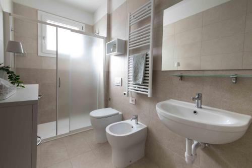 BIA'S Beach - appartamenti fronte mare في بيبيوني: حمام أبيض مع حوض ومرحاض
