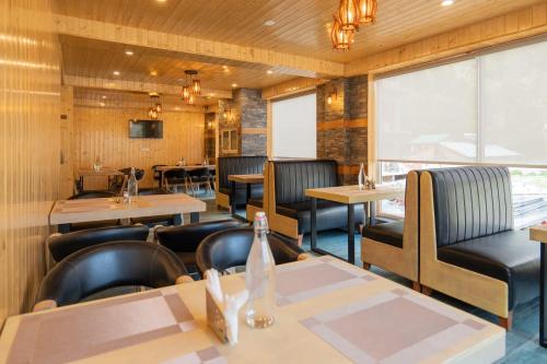 Un restaurante con mesas y sillas y una ventana. en Hotel Patalsu, en Palchān